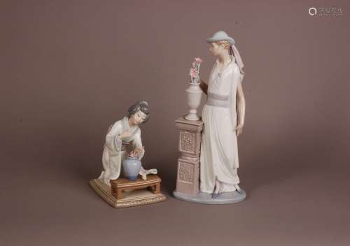 Two modern Lladro figures, one of an elegant lady stood with...