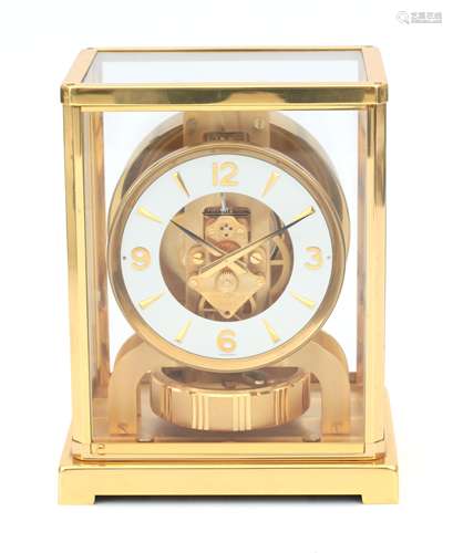 A perpetuum moving clock in gold-plated metal and glass case...