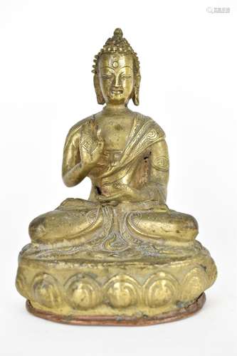 A Tibetan statue of Buddha seated in Abhaya Mudra on a lotus...