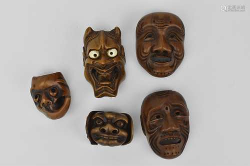 A collection of five Japanese carved wood mennetsuke (netsuk...