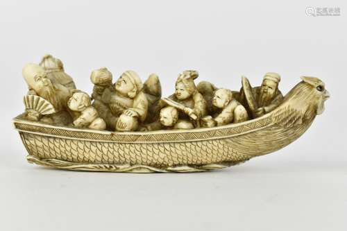 A Japanese Meiji period ivory netsuke of a boat crowed with ...