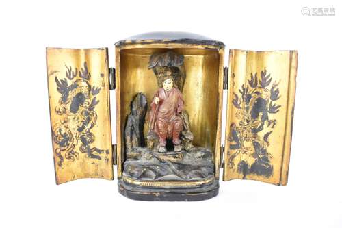 A Chinese lacquered travelling shrine, with a deity seated o...