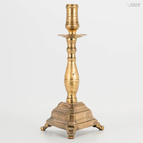 An antique candlestick made of bronze.