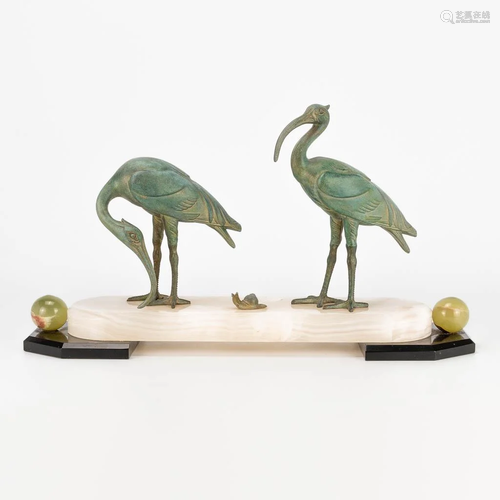 An art deco style statue of 2 ibis birds with a snail,