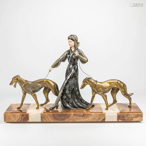 An art deco group of a lady walking her two dogs,