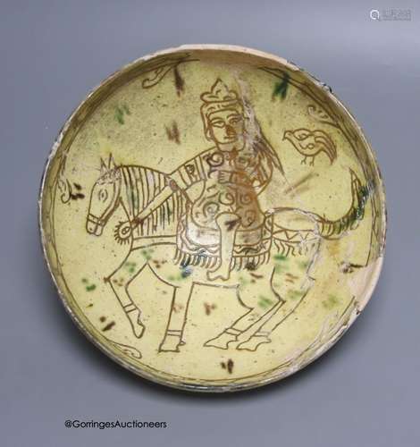 An Islamic pottery bowl decorated with a figure on horseback...