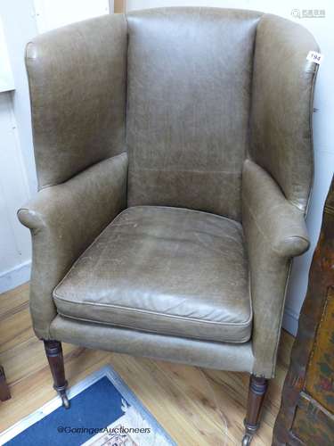 A Regency barrel back wing armchair upholstered in pale gree...