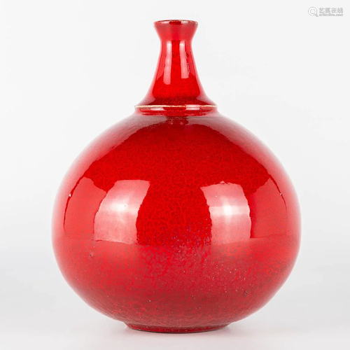 A vase made of red glazed white ceramics and probably