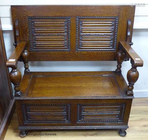 A 17th century style oak box seat monk's bench, width 107cm,...