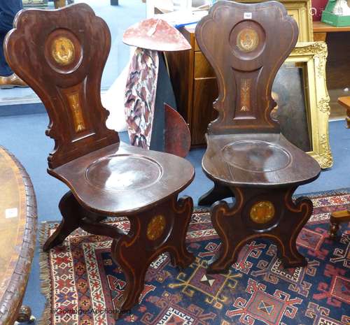 A pair of 19th century walnut hall chairs with painted armor...