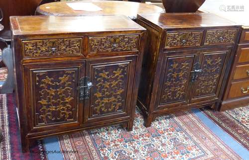 A pair of Chinese carved cabinets, the fronts carved with fo...