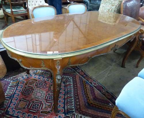 An oval gilt metal mounted Continental dining table, length ...