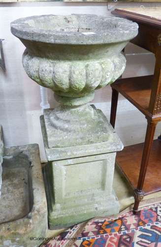 A reconstituted stone campana garden urn on plinth, 40cm dia...