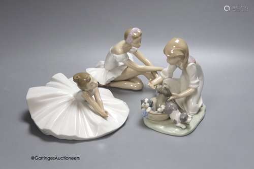 A Lladro figure of a ballerina and a child playing with dogs...