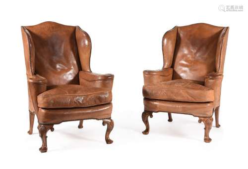 A PAIR OF WALNUT AND LEATHER UPHOLSTERED WING ARMCHAIRS, IN ...