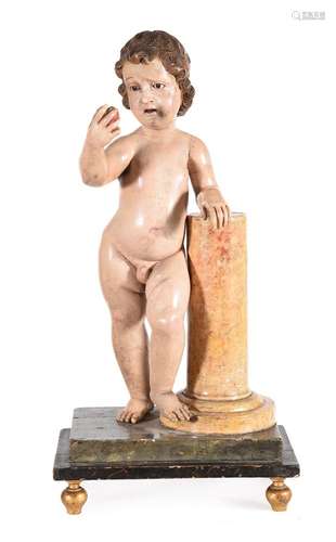 A POLYCHROME AND GILT PAINTED SOFTWOOD FIGURE OF A CHILD BEA...