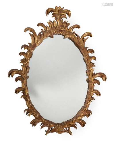 A GEORGE III CARVED GILTWOOD OVAL WALL MIRROR, IN THE MANNER...