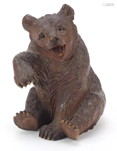 Carved Black Forest seated bear with raised paw and