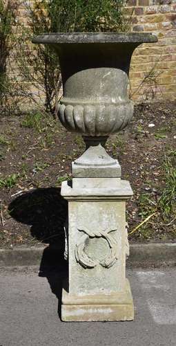 A MARBLE CAMPANA URN ON A LIMESTONE PEDESTAL BASE, THE URN E...