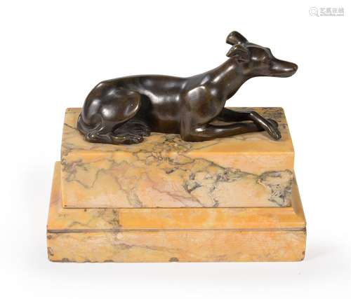 A BRONZE MODEL OF A RECUMBENT GREYHOUND, IN THE MANNER OF TH...