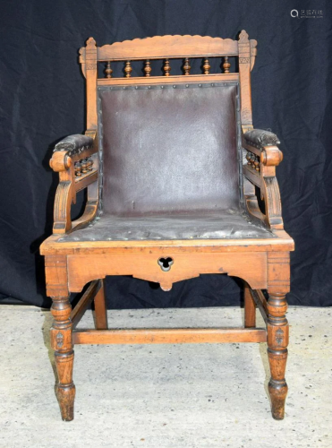 A Victorian wooden & leather upholstered armchair. 102