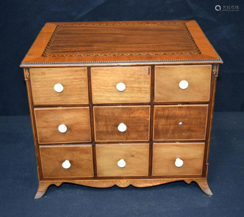 A small antique wooden inlaid storage cabinet with nine