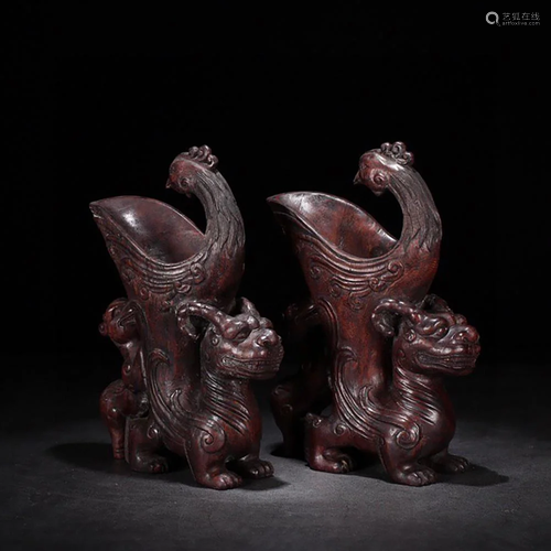 A PAIR OF CARVED EAGLEWOOD MYTHICAL BEASTS