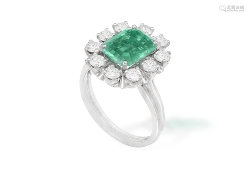 AN EMERALD AND DIAMOND CLUSTER RING The central