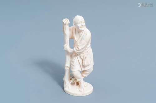 A Japanese ivory okimono of a farmer leaning against a tree,...