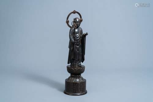 A Japanese bronze figure of Buddha on an inscribed lotus bas...