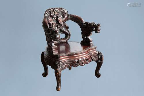 A Chinese or Japanese carved wooden 'dragons' chair, 20th C.