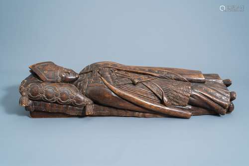 A French or Flemish carved wooden figure of a bishop on his ...