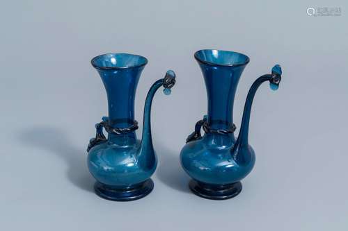 A pair of Islamic blue coloured relief decorated glass ewers...