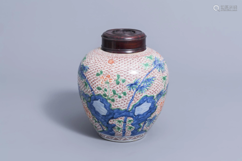 A Chinese wucai jar and wooden cover with floral