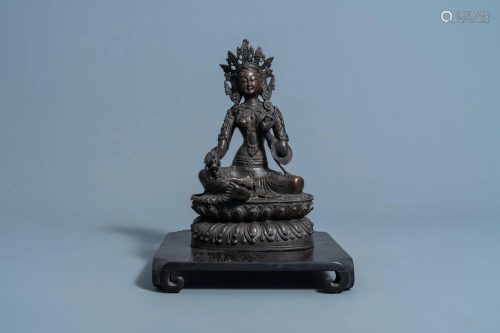 A Sino-Tibetan bronze figure of Tara on a wood base,