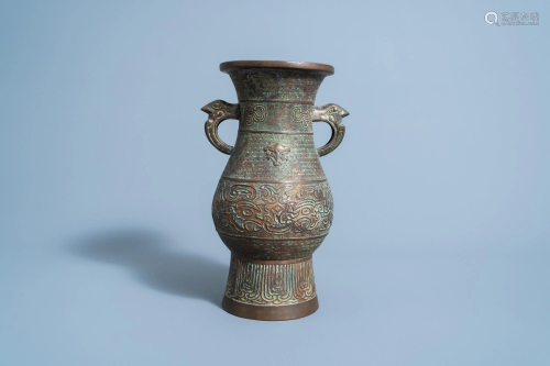 A Chinese archaic bronze vase with bird head handles,