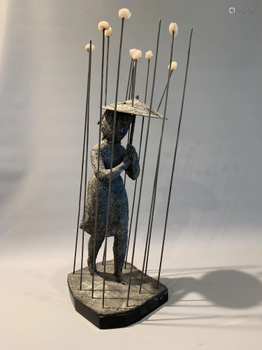 A patinated iron figure of a lady with an umbrella