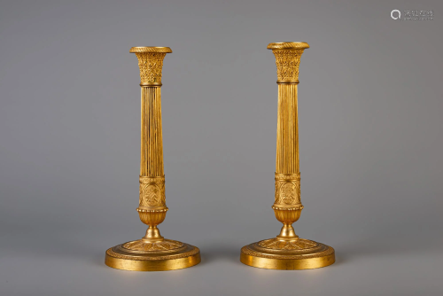 A pair of French Neoclassical gilt bronze candlesticks,