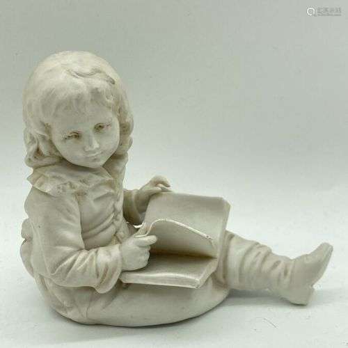 Enfant lisant. Sujet en biscuit. Vers 1900. H. 10 cm.