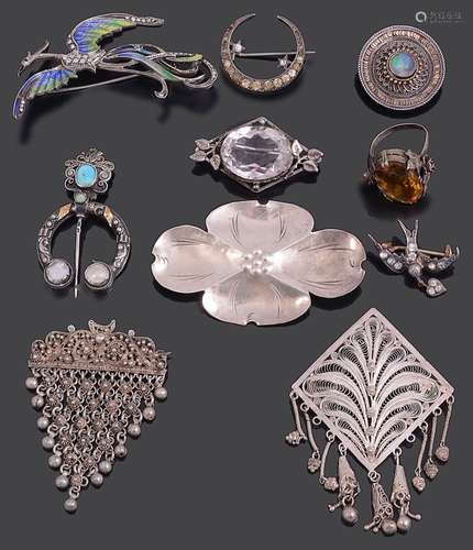 A collection of various silver brooches