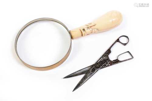 A pair of steel scissors; and a magnifying glass