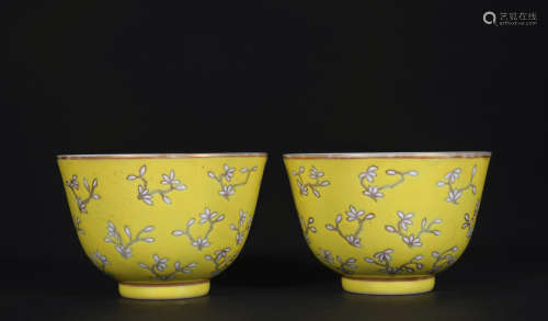 A pair of yellow glazed 'floral' cup