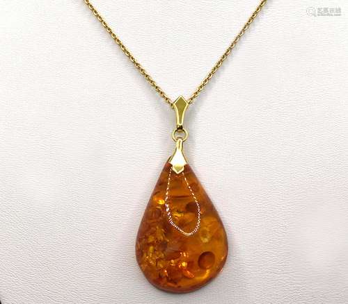 Drop shaped amber pendant with natural inclusions, set in 33...