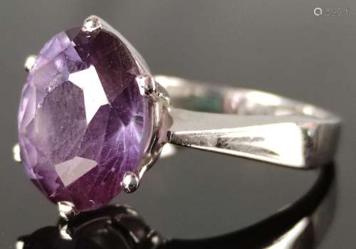 Ring with large faceted gemstone in purple (probably colored...