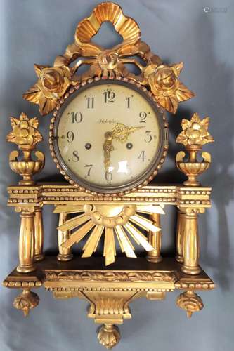 Cartel clock, elaborately carved wooden case, gilt, in class...