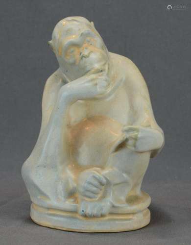 Reading monkey sitting cross-legged on a round base, light g...