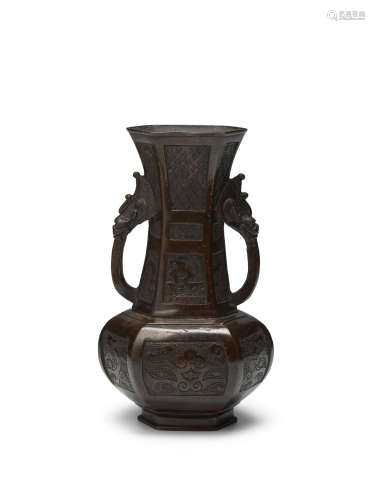 A well-cast archaistic patinated bronze hexagonal two-handle...
