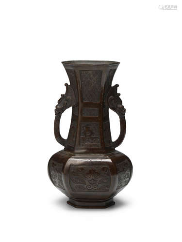 A well-cast archaistic patinated bronze hexagonal two-handle...