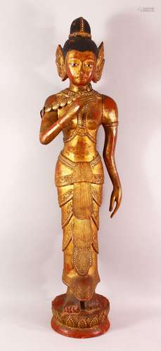 A LARGE THAI GILT AND RED LACQUER CARVED WOOD FIGURE, standi...