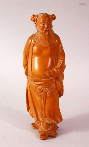 A CHINESE CARVED HARD WOOD FIGURE OF AN IMMORTAL - the figur...